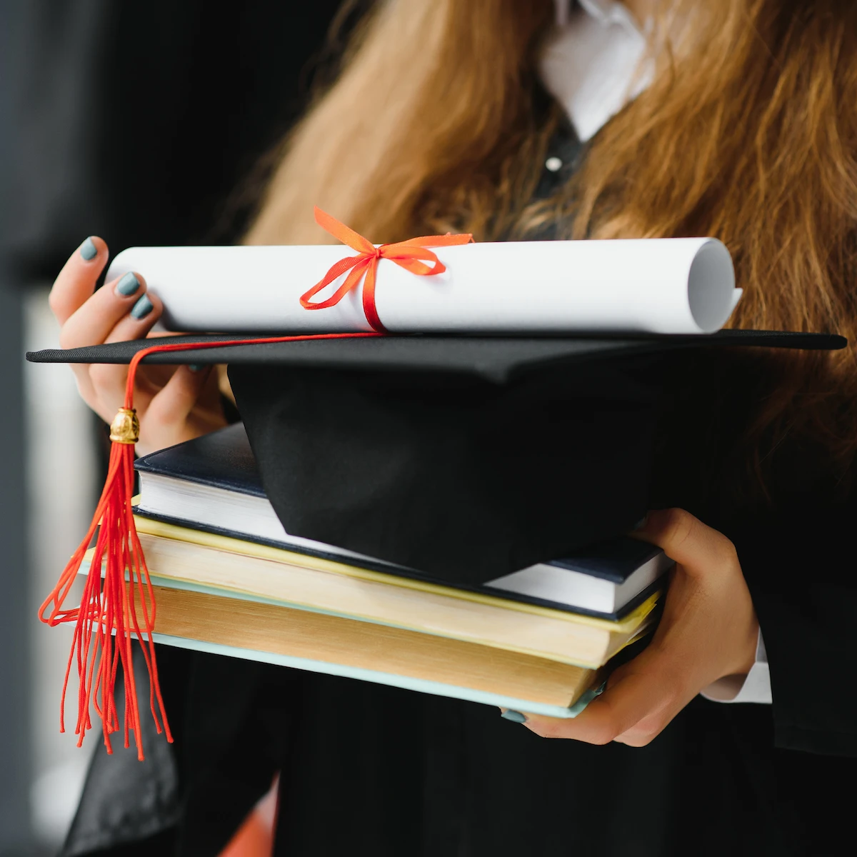 female-student-holding-diploma-books